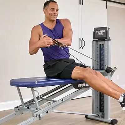 Man using a Total gym evolve exercise machine in a home gym setting