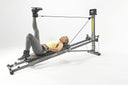 Woman doing a leg exercise with ankle cuffs on the Total Gym FIT Anniversary Edition